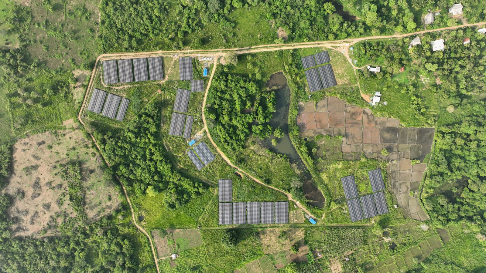 Solar arrays laid out across cleared land beside a rural road in Sri Lanka
