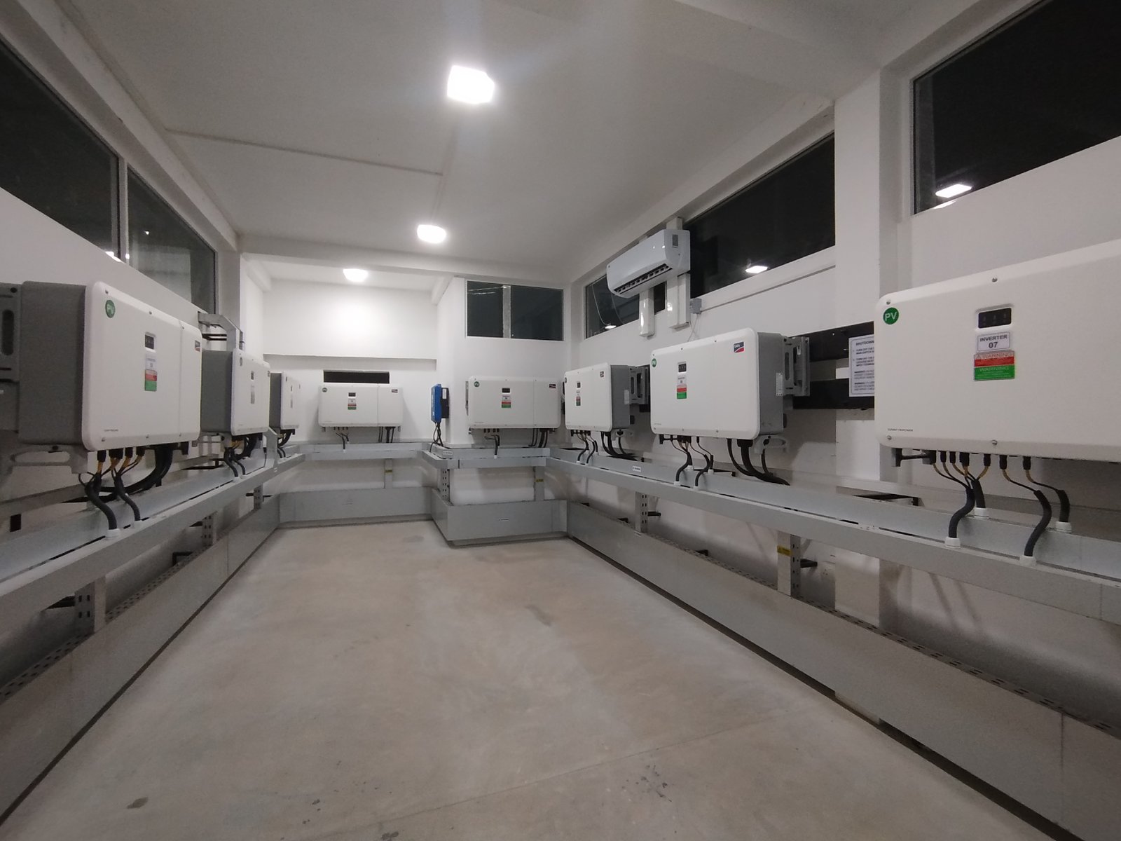 Row of solar inverters installed in a clean plant room